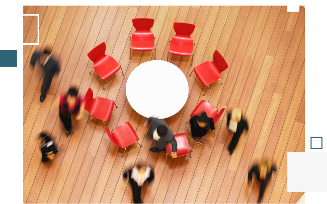 Overhead view of a round table with an advisory committee of people walking around it